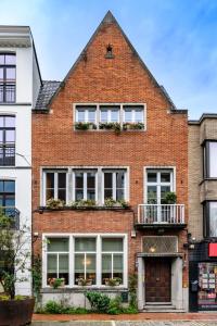 a red brick house with windows and balconies at B&B l'Inconnu in Roeselare
