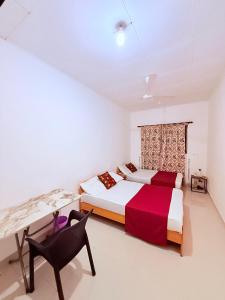 a bedroom with two beds and a desk and a chair at Thalpe Gedara Villa in Talpe