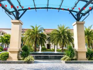 a fountain in front of a building with palm trees at V Hạ Long in Ha Long