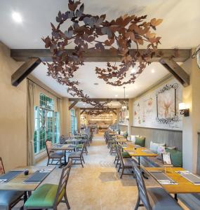 a dining room with tables and chairs and a chandelier at U Khao Yai in Mu Si
