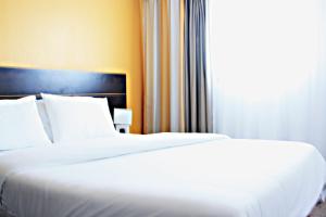 two white beds in a hotel room with a window at City Résidence Aix-en-Provence in Aix-en-Provence