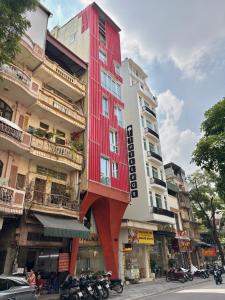 a red building on the side of a street at J Village Hotel - Triệu Việt Vương in Hanoi