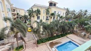 an overhead view of a building with a pool and palm trees at Triyaah Pool View Studios Arpora, Goa in Arpora