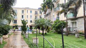 a courtyard with palm trees and a building at Triyaah Pool View Studios Arpora, Goa in Arpora