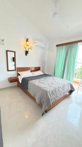 a bedroom with a bed with a green curtain at Triyaah Pool View Studios Arpora, Goa in Arpora