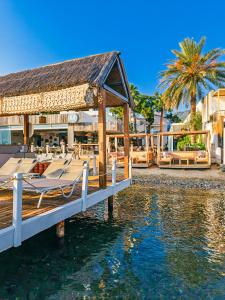 a dock with a table and chairs on the water at Babana Hotel in Golturkbuku