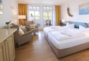 a hotel room with a large bed and chairs at Hotel Villa Granitz in Baabe +60 photos