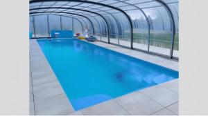 a swimming pool in a building with an open structure at Domki Letniskowe Maks in Bobolin
