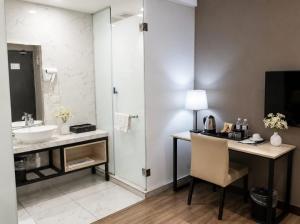 a bathroom with a sink and a desk with a mirror at The Leverage Business hotel (Skudai) in Johor Bahru +36 photos