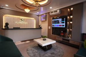 a living room with a tv and a coffee table at Hotel Sharma Jaipur in Jaipur