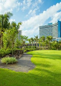a golf course with palm trees and a building at Renaissance Haikou Hotel in Haikou