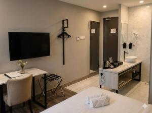a bathroom with a sink and a shower with a tv on the wall at The Leverage Business hotel (Skudai) in Johor Bahru