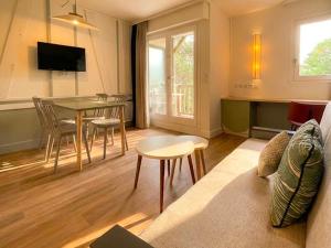 a living room with a table and a dining room at Residence Pierre & Vacances Les Embruns in Deauville