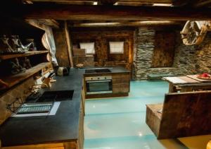 a large kitchen with a stove and a stone wall at Casa Rural Mariola in Ordino