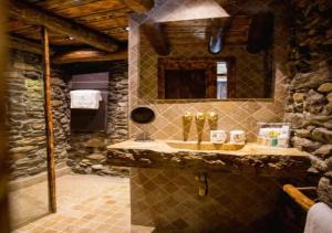 a stone bathroom with a sink and a mirror at Casa Rural Mariola in Ordino +35 photos