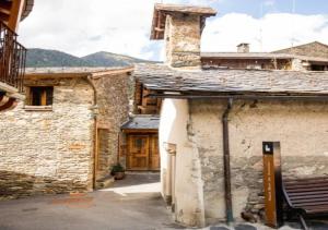 an old stone building with a door in a courtyard at Casa Rural Mariola in Ordino