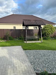 a pavilion with a bench in front of a house at Luci's House in Jucu de Mijloc