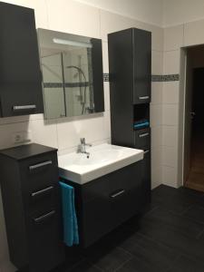 Un baño con un lavabo blanco y un espejo. en Villa am Hülser Berg nähe Düsseldorf, en Krefeld