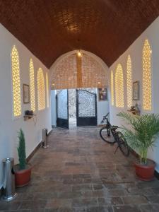 a room with a hallway with a door and some plants at Nefertiti Guest House in ‘Ezbet Abu Ḥabashi