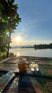 a coffee cup and a flower sitting on a table at บ้านสวนริมอ่าง in Phayao