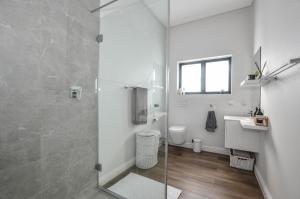 a bathroom with a shower and a toilet and a sink at Caracal 54 in Yzerfontein +24 photos