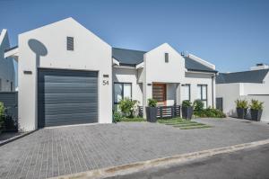 a white house with a garage at Caracal 54 in Yzerfontein