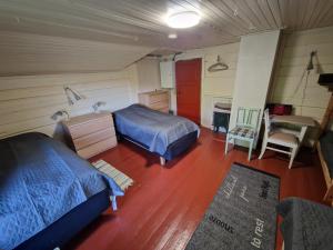 a bedroom with two beds and a sink and a table at Åreholtet log cabin, Norway in Kleppo
