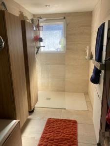 a small bathroom with a shower and a red rug at Arlette Guest House in Essarts +3 photos