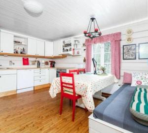 a kitchen with a table and red chairs in a room at Åreholtet log cabin, Norway in Kleppo