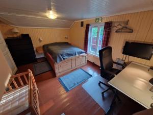 a room with a bed and a desk and a television at Åreholtet log cabin, Norway in Kleppo