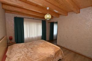 a bedroom with a bed in a room with wooden ceilings at Hilltop Jikha in Jikhaskari