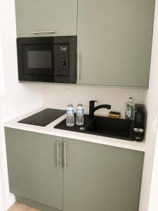 a kitchen with a sink and a microwave at La Chambre Deauvillaise in Deauville