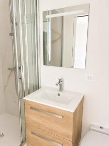 a bathroom with a sink and a mirror at La Chambre Deauvillaise in Deauville