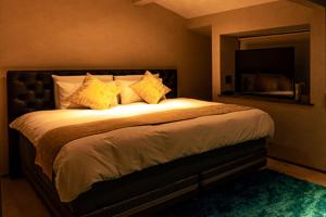 a bedroom with a large bed with yellow pillows at OOkami Villa in Omachi