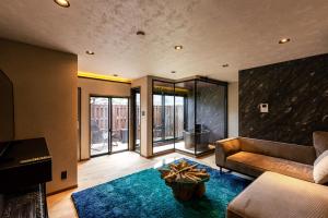 a living room with a couch and a fireplace at OOkami Villa in Omachi