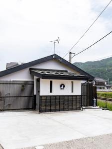 a white and black garage with a black fence at OOkami Villa in Omachi