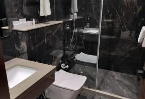 a bathroom with a toilet and a sink and a shower at Park Central Hotel in Ahmadnagar +29 photos