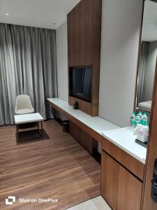 a hotel room with a desk and a tv and a chair at Park Central Hotel in Ahmadnagar