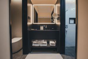 a bathroom with a sink and a mirror and a toilet at PingYao Chengfu Jinyuan Hotel in Pingyao
