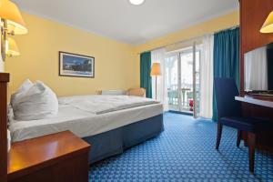 a hotel room with a bed and a window at Neptun Hotel Kühlungsborn in Kühlungsborn