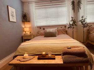 a bedroom with a bed with two candles on a table at Honeydon in Eaton Socon +9 photos