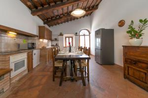 a kitchen with a table with chairs and a refrigerator at Villa Adelmo appartamento privato in Pomarance