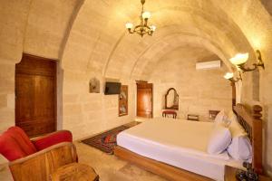 a bedroom with a large bed in a stone room at Mithra Cave Cappadocia in Göreme