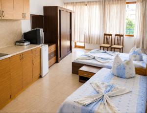a hotel room with two beds and a kitchen at Къща за гости Уют in Sveti Vlas