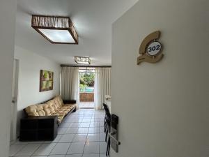 a living room with a couch and a clock on the wall at Gran Lençóis Flat Residence - Flat 302 in Barreirinhas
