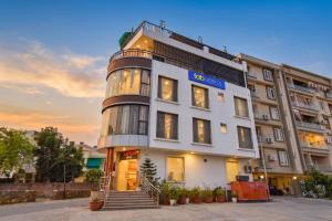 a large white building with a sign on it at FabHotel Kirara - Nr Jaipur International Airport in Jaipur