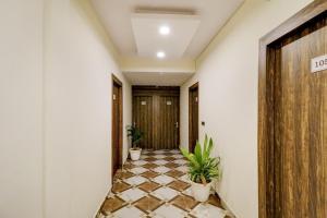 a hallway with a tiled floor and two potted plants at Hotel O Times Square in Indraprast +20 photos