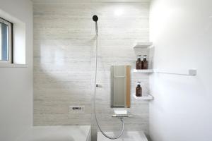 a bathroom with a shower with a toilet and a sink at The CATAN 宮津 in Yura +45 photos