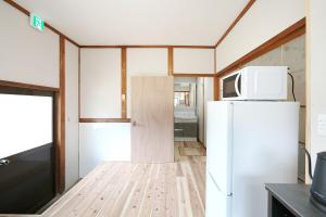a small kitchen with a refrigerator and a microwave at The CATAN 宮津 in Yura