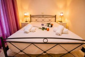 a bedroom with a bed with two towels and two lamps at Aias Summer House in Aiándion